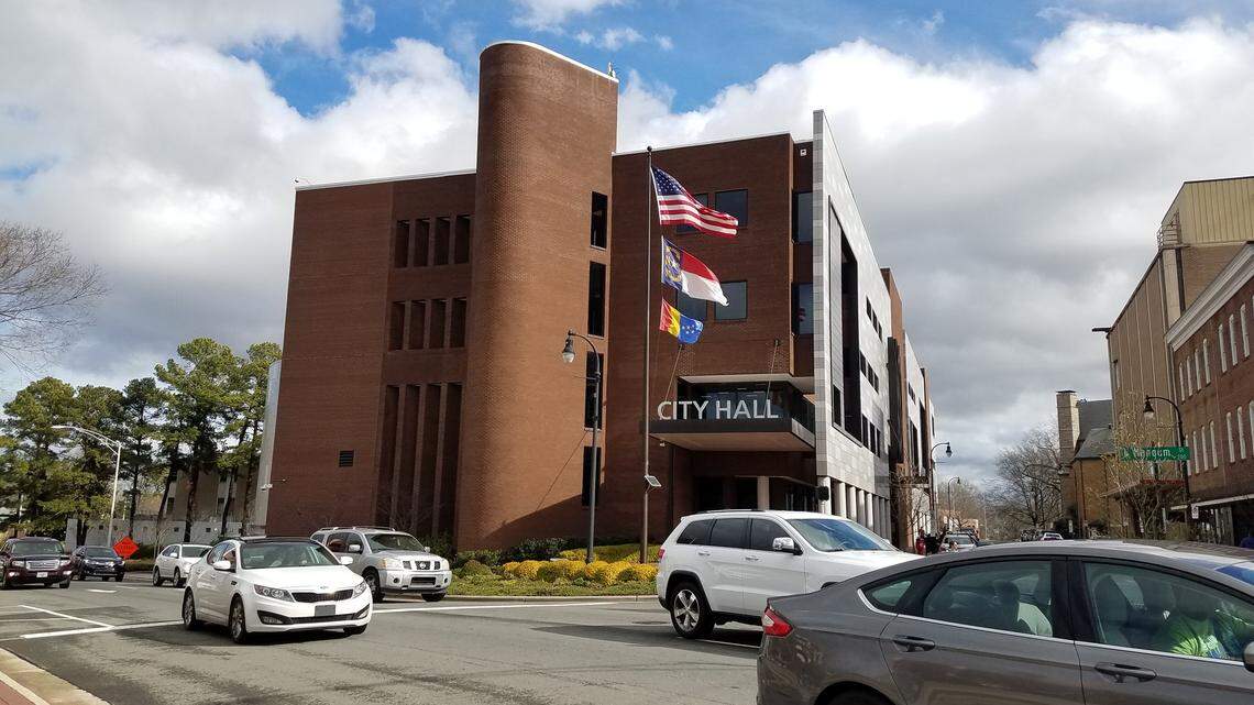 Cars drive down Mangum Street past Durham City Hall in January 2019.