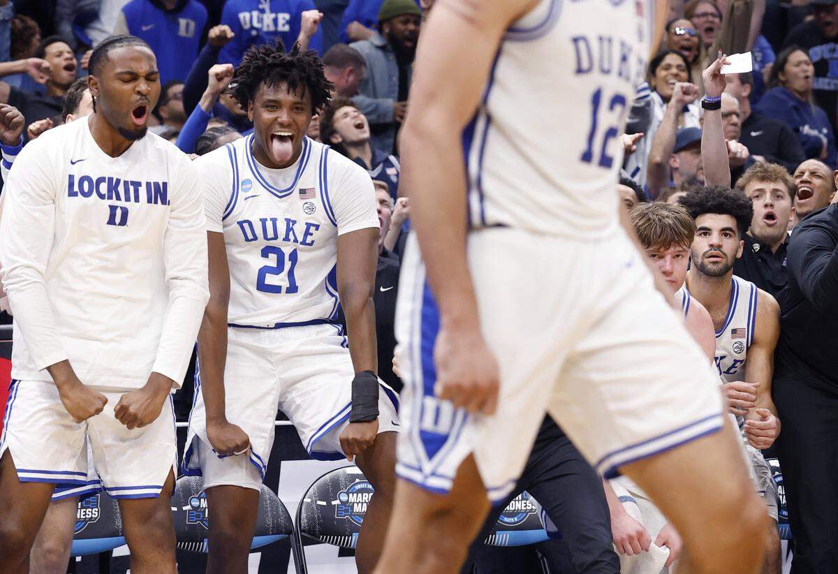 The Duke bench, including Patrick Ngongba II (21) and Sebastian Wilkins, celebrates after Cameron Boozer made the basket while being fouled during the second half of Duke’s 80-75 victory over St. John’s in the Sweet 16 of the NCAA Men’s Basketball East Regional at Capital One Arena in Washington, D.C., Friday, March 27, 2026.