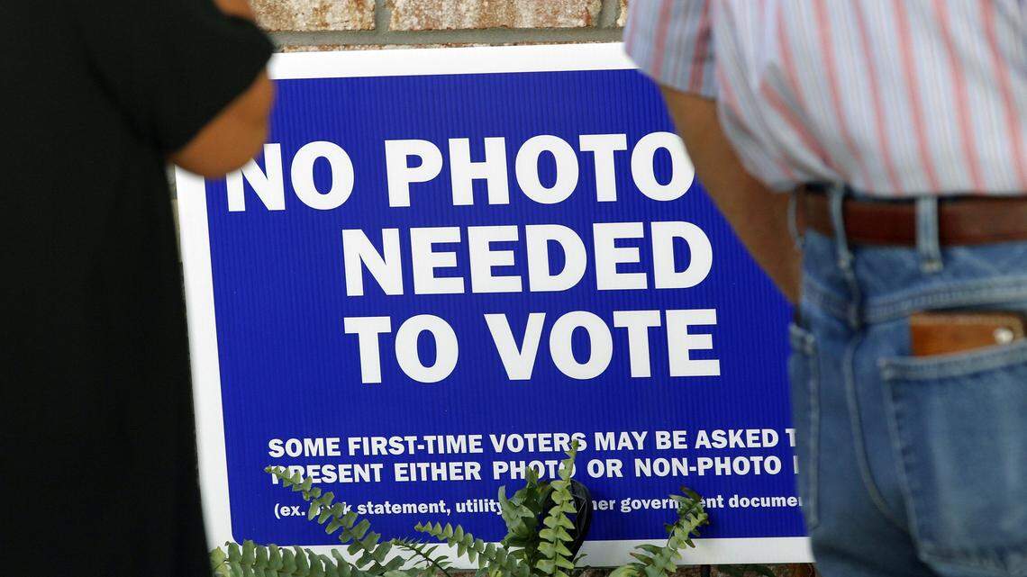 A sign tells voters a photo ID is not required as hundreds  come out on the first day of early voting at the Hope Mills Recreation Center in Hope Mills on Oct. 20, 2016.