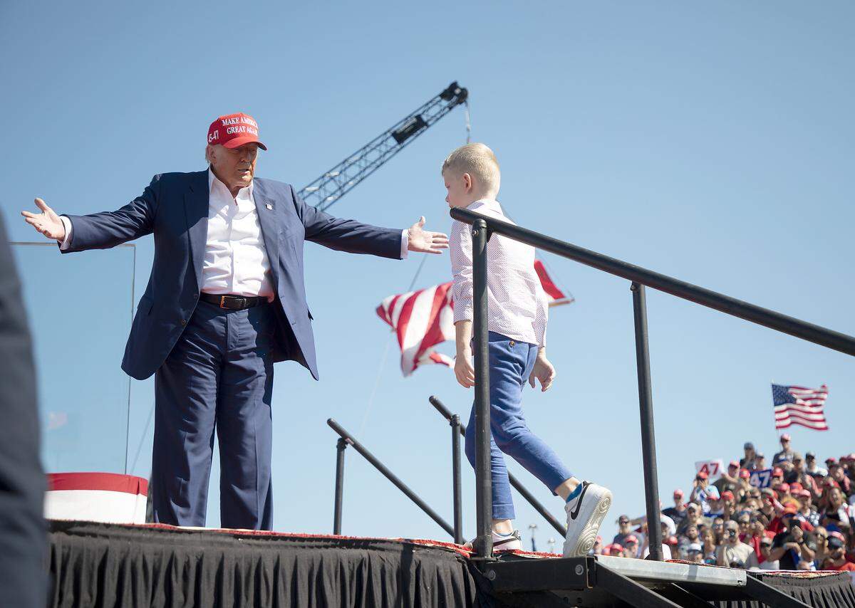 Former President and current Republican candidate for president Donald Trump greets his grandson, Luke, at a rally in Wilmington, N.C. on Saturday, Sept. 21, 2024.