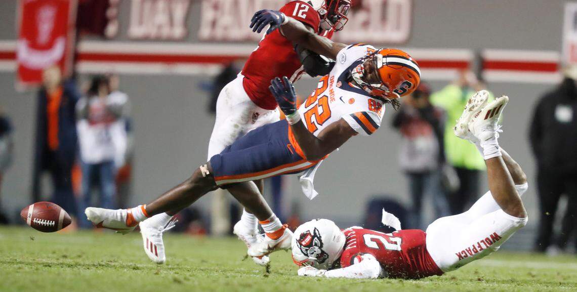 Syracuse wide receiver Damien Alford (82) is hit by linebacker Devan Boykin (12) after failing to pull in a reception during the first half of N.C. State’s game against Syracuse at Carter-Finley Stadium in Raleigh, N.C., Saturday, Nov. 20, 2021. N.C. State cornerback Derrek Pitts Jr. (24) is also in on the defense.