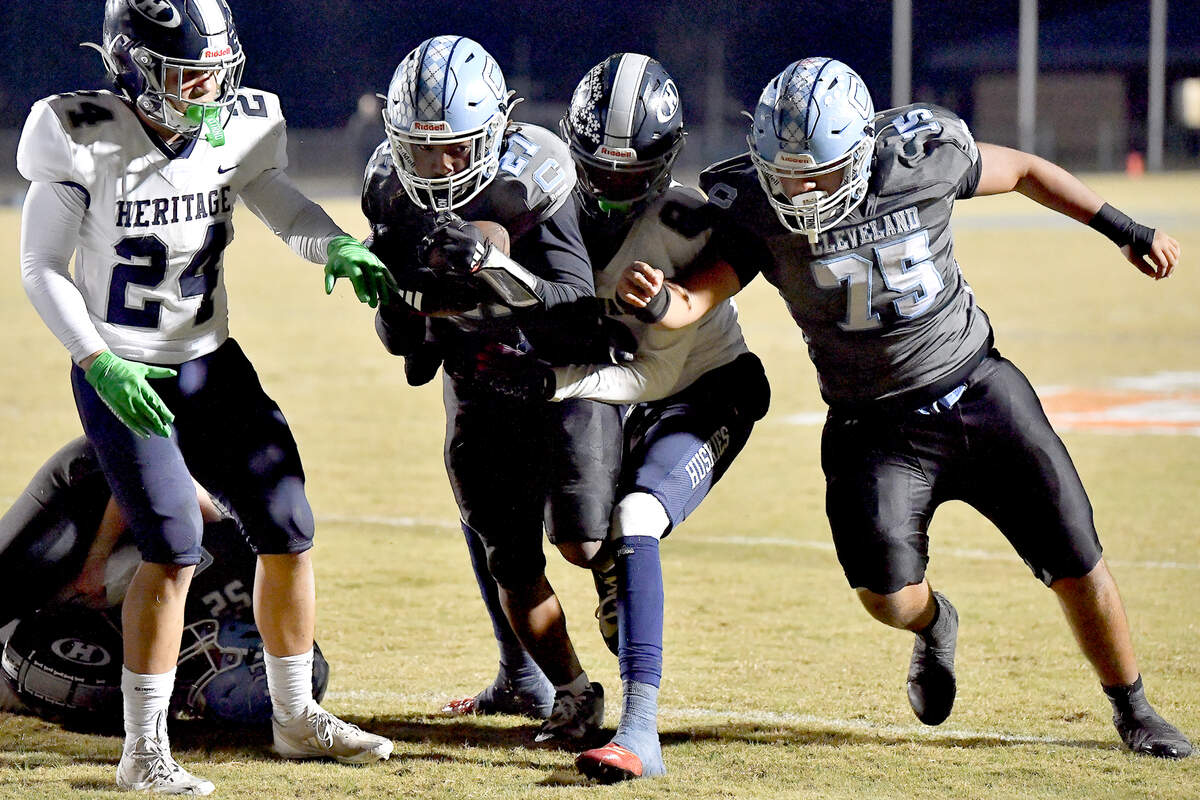 Cleveland running back Kaleb Ferrell (27) runs the short yards for the touchdown against Heritage’s Daries Carter (8) during the first half. The Cleveland Rams and the Heritage Huskies met in the first round of the NCHSAA 4A playoffs in Clayton, N.C. on November 15, 2024.