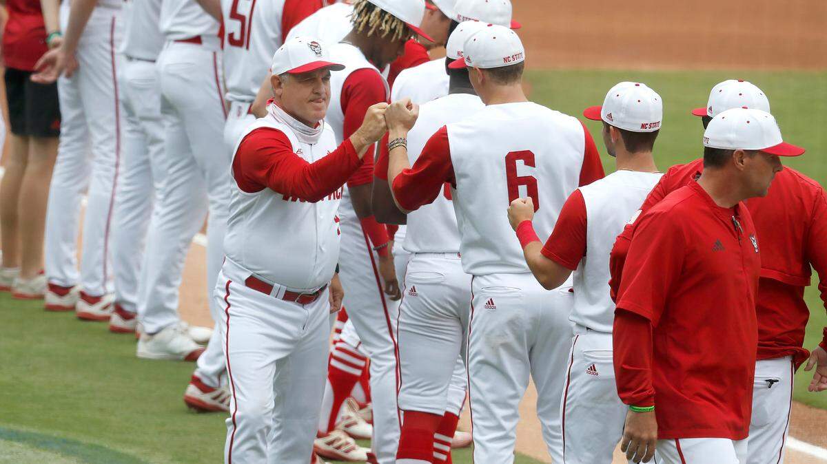 N.C. State head coach Elliott Avent greets players, including Vojtech Mensik (6) during introductions before during N.C. State’s game against Duke in the ACC Baseball Championship game at Truist Field in Charlotte, N.C., Sunday, May 30, 2021.