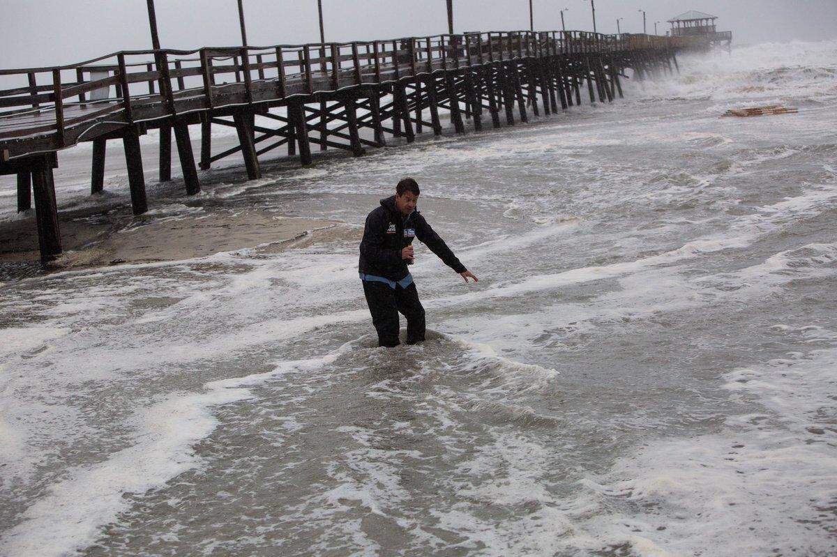 A television reporter stands in the ocean at Atlantic Beach during Hurricane Florence.