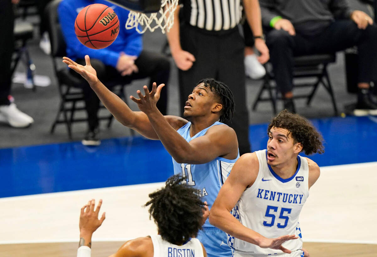 North Carolina’s Day’Ron Sharpe (11) tries to get a rebound ahead of Kentucky’s Lance Ware (55) and Brandon Boston Jr. (3) in the first half of an NCAA college basketball game, Saturday, Dec. 19, 2020, in Cleveland.