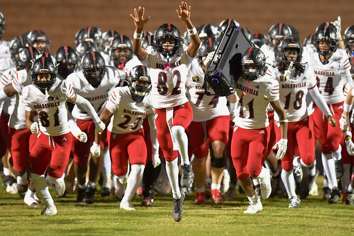 Rolesville wide receiver Deshaun Nesbitt (82) and teammates run onto the field before their playoff game against Apex Friendship. The Apex Friendship Patriots and the Rolesville Rams met in  the second round of the  NCHSAA 8A Playoff game in Apex, N.C. on November 14, 2025. Rolesville wins 14-7 in overtime.