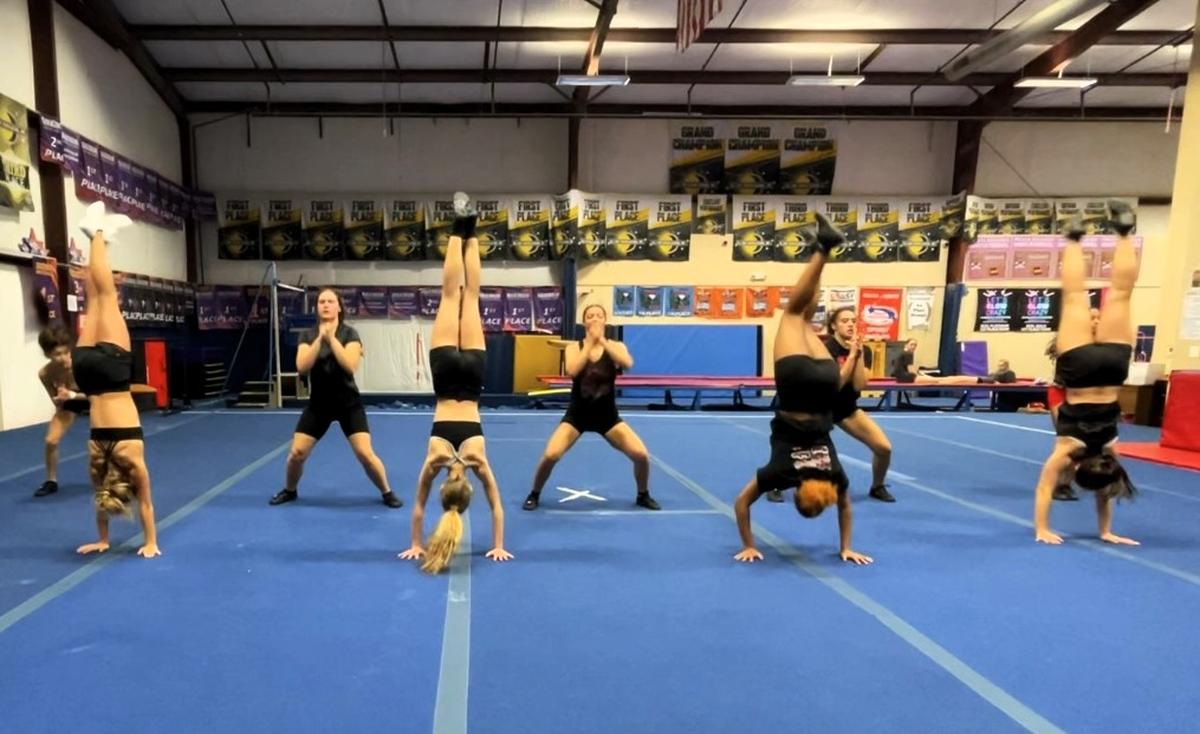 Members of the Outlaw cheerleading team at Hillsborough Cheer Dance and Gymnastics complete a series of flips during their practice routine at the studio in Orange County on Wednesday, Nov. 13, 2024.