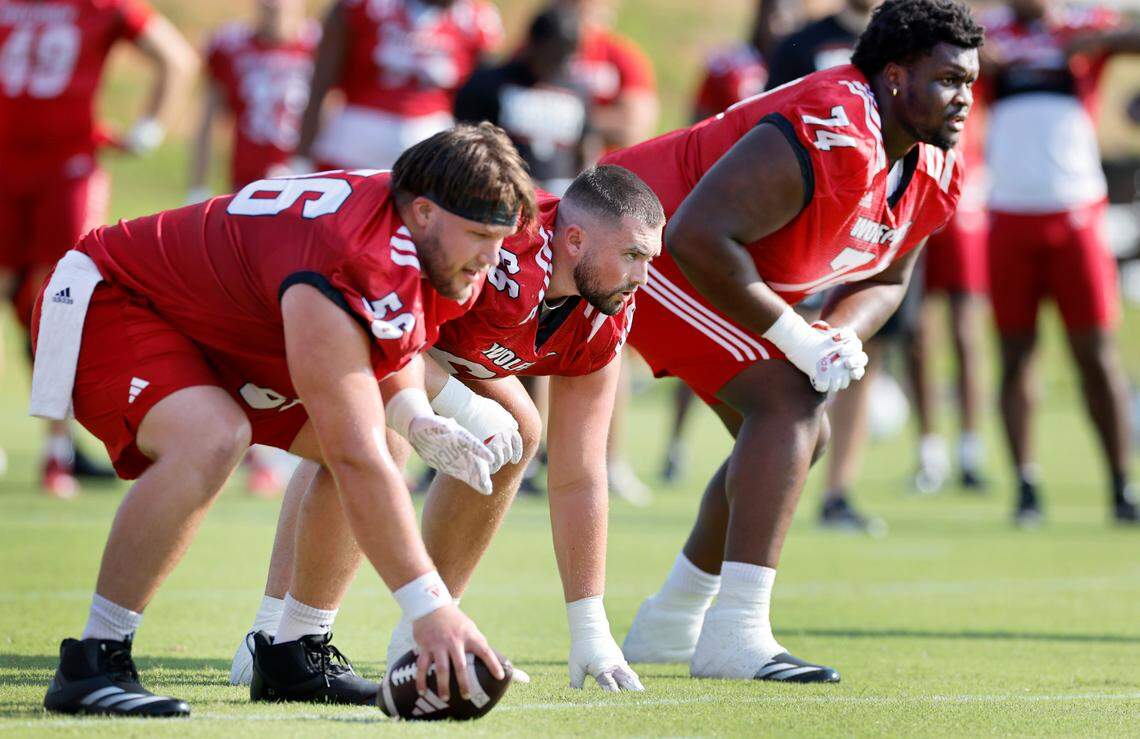 N.C. State’s Matt McCabe (66), center, along with Zeke Correll (56), left, and Anthony Belton (74) line up during the Wolfpack’s first practice in Raleigh, N.C., Wednesday, July 31, 2024.