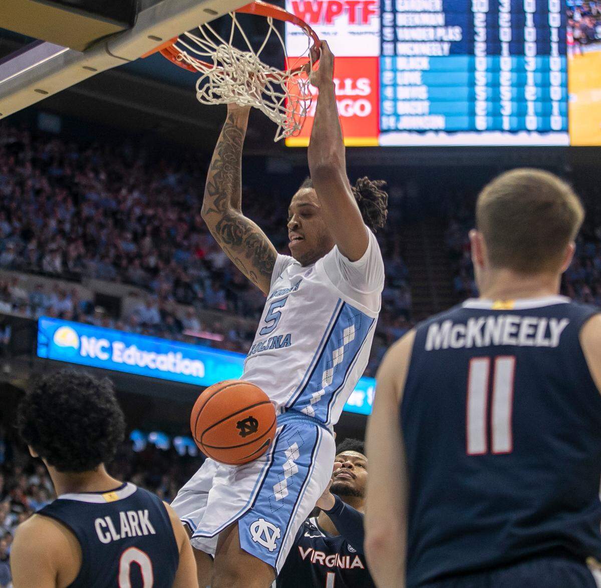 North Carolina’s Armando Bacot (5) dunks over Virginia’s Kihei Clark (0), Jayden Gardner (1), and Isaac McKneely (11) in the first half on Saturday, February 25, 2023 at the Smith Center in Chapel Hill, N.C.