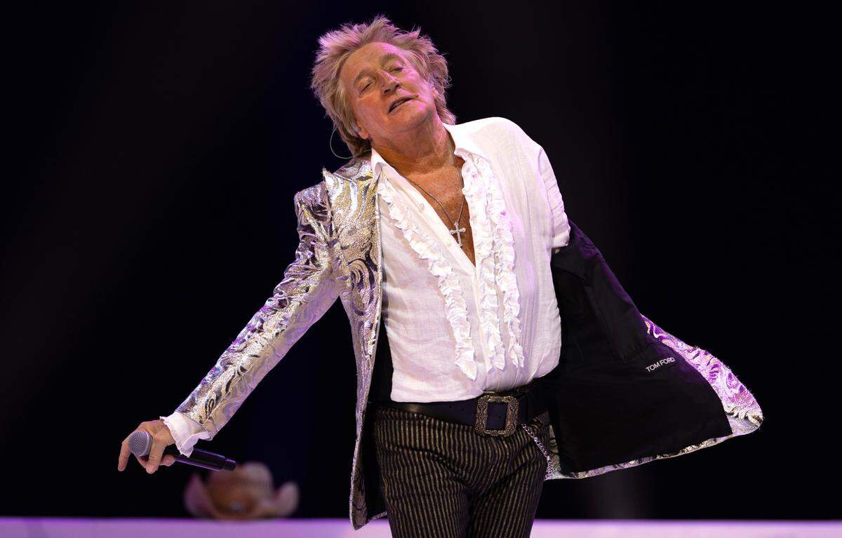 Rod Stewart, fancy jacket slung off of a shoulder, works the crowd on his “One Last Time” tour show at Raleigh, N.C.’s Coastal Credit Union Music Park at Walnut Creek, Tuesday night, July 8, 2025.