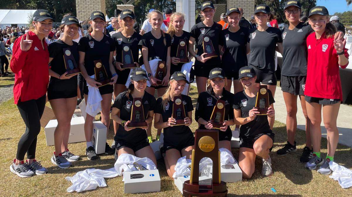 The NC State women’s cross country team poses with the NCAA Championship Trophy after capturing the first NCAA national title in school history.