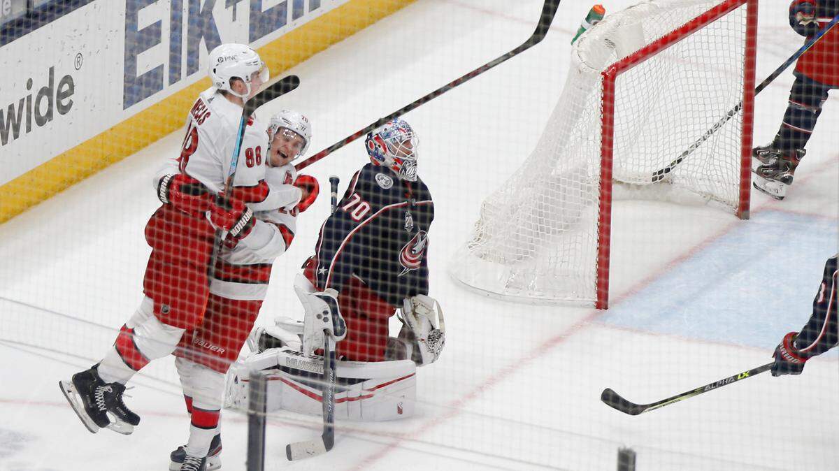 Carolina Hurricanes’ Martin Necas, left, and Sebastian Aho celebrate a goal against Columbus Blue Jackets’ Joonas Korpisalo in overtime of an NHL hockey game Thursday, March 25, 2021, in Columbus, Ohio. The Hurricanes won 4-3. (AP Photo/Jay LaPrete)