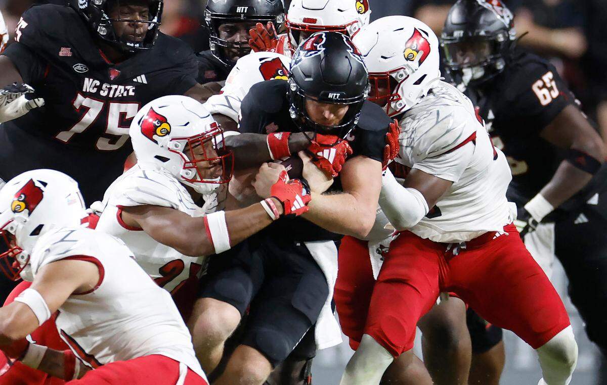 N.C. State quarterback Brennan Armstrong (5) is wrapped up by the Louisville defense during the second half of Louisville’s 13-10 victory over N.C. State at Carter-Finley Stadium in Raleigh, N.C., Friday, Sept. 29, 2023.