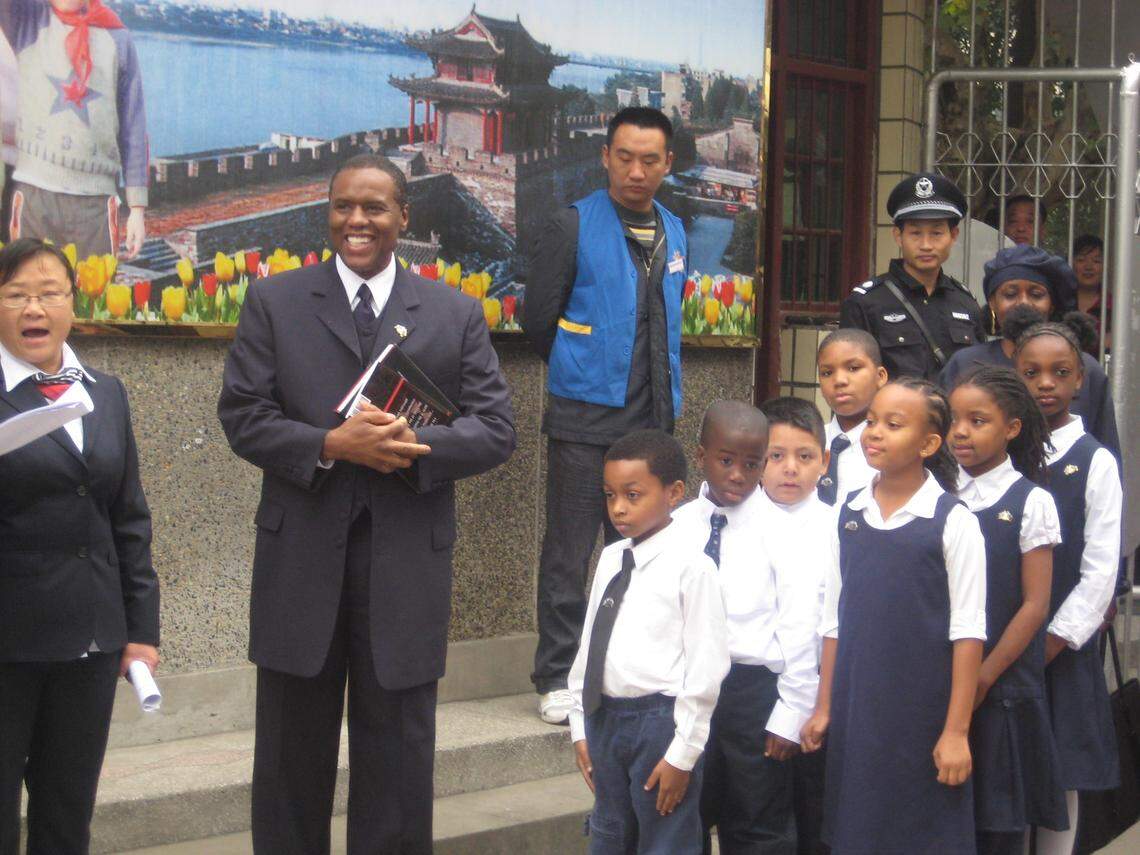 Torchlight Academy students line up before a visit to Primary Experimental School No. 1 in Xiangfan, China. From front to back in the boys line are Isaac Montague, Jordan Williams, Andy Mendez and Emperor Davis. The girls, from front to back, are Hasana Muhammad, Heaven Davis and Toni McLean. Holding books at left is Don McQueen, Torchlight Academy’s executive director.