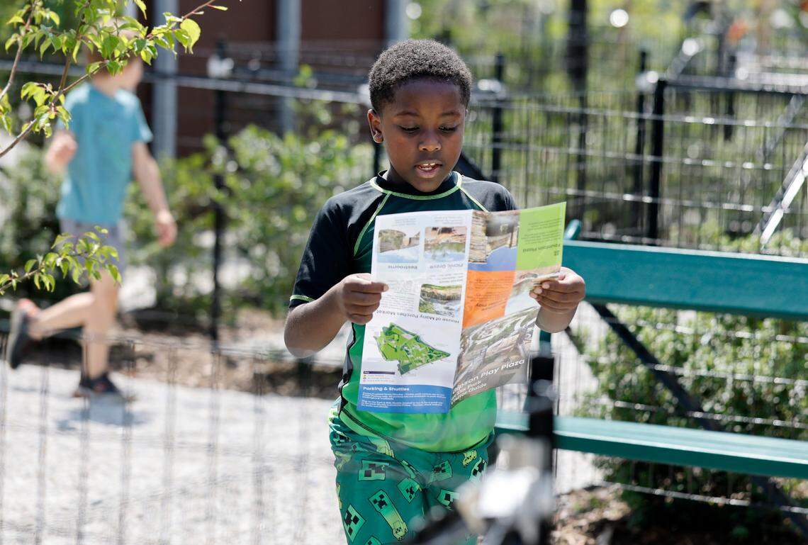 Gabriel Glenn, 7, of Raleigh uses a map to find where to go next at Gipson Play Plaza at Dix Park during a preview day Saturday, May 24, 2025. The park will officially open with a grand opening celebration on June 6th, 7th and 8th.