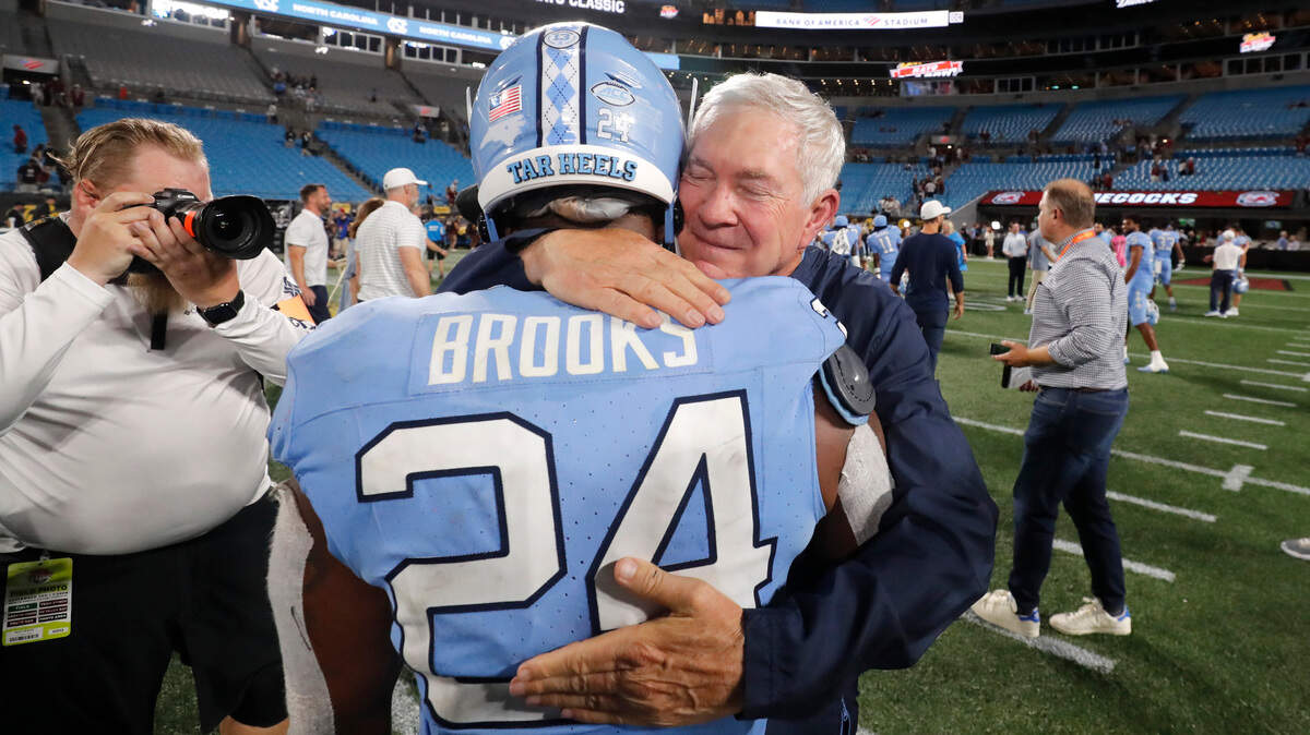 North Carolina head coach Mack Brown hugs running back British Brooks (24) after UNC’s 31-17 victory over South Carolina in the Duke’s Mayo Classic at Bank of America Stadium in Charlotte, N.C., Saturday, Sept. 2, 2023.