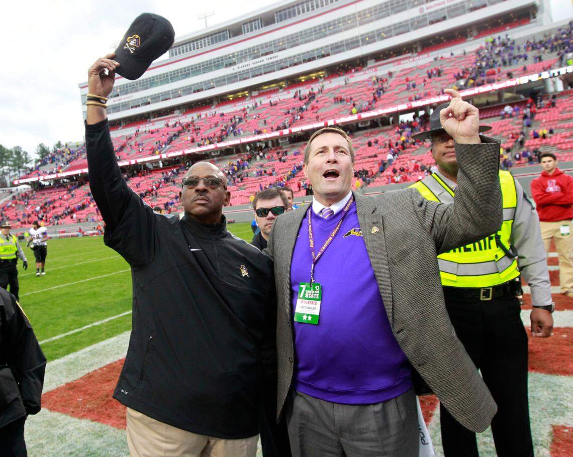 East Carolina head coach Ruffin McNeill, left, celebrates with ECU Director of Athletics Jeff Compher and the fans after East Carolina’s 42-28 victory over N.C. State at Carter-Finley Stadium in 2013.