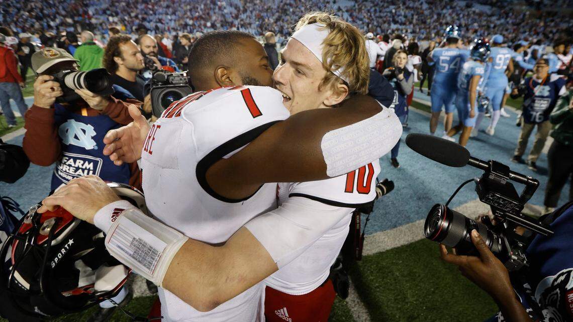 N.C. State linebacker Isaiah Moore (1) and quarterback Ben Finley (10) hug after N.C. State’s 30-27 overtime victory over UNC at Kenan Stadium in Chapel Hill, N.C., Friday, Nov. 25, 2022.