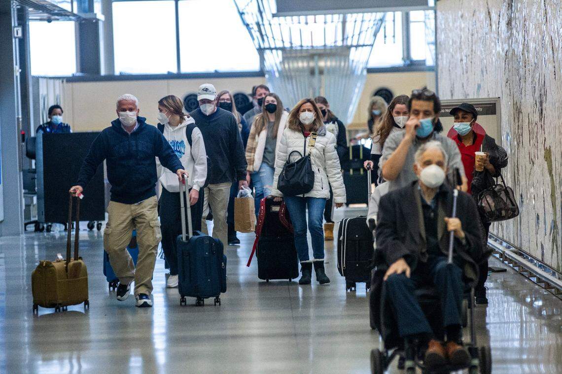 Travelers arrive at Raleigh-Durham International Airport in Morrisville Tuesday, Dec. 21, 2021.