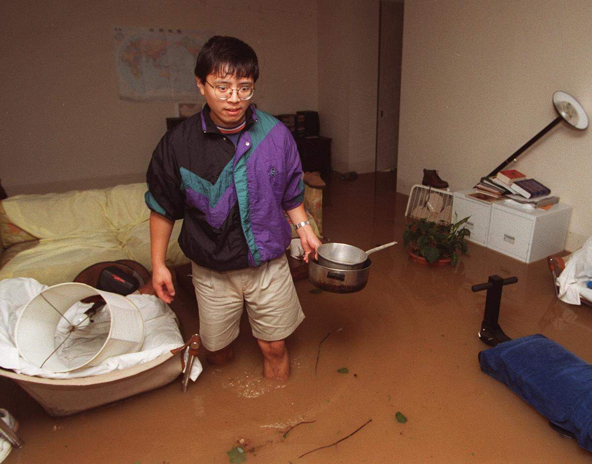 A shocked Song Qian wades through his flooded apartment at Kensington Park Apartments after it flooded as Hurricane Fran passed through. He was not sure where the pots and pans came from. They were not his.