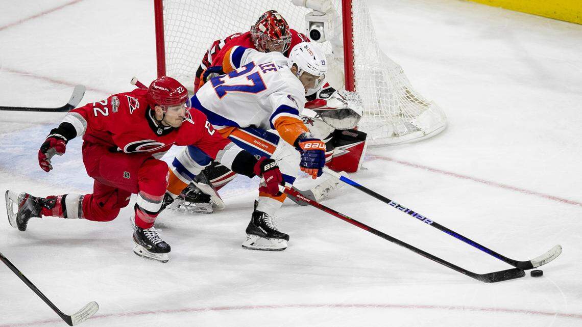 Carolina’s Hurricanes’ Brett Pesce (22) battles for control of the puck with New York Islanders’ Anders Lee (27) in front Hurricanes’ goalie Antii Raanta (32) during the closing minutes of play on Monday, April 17, 2023 at PNC Arena in Raleigh, N.C.