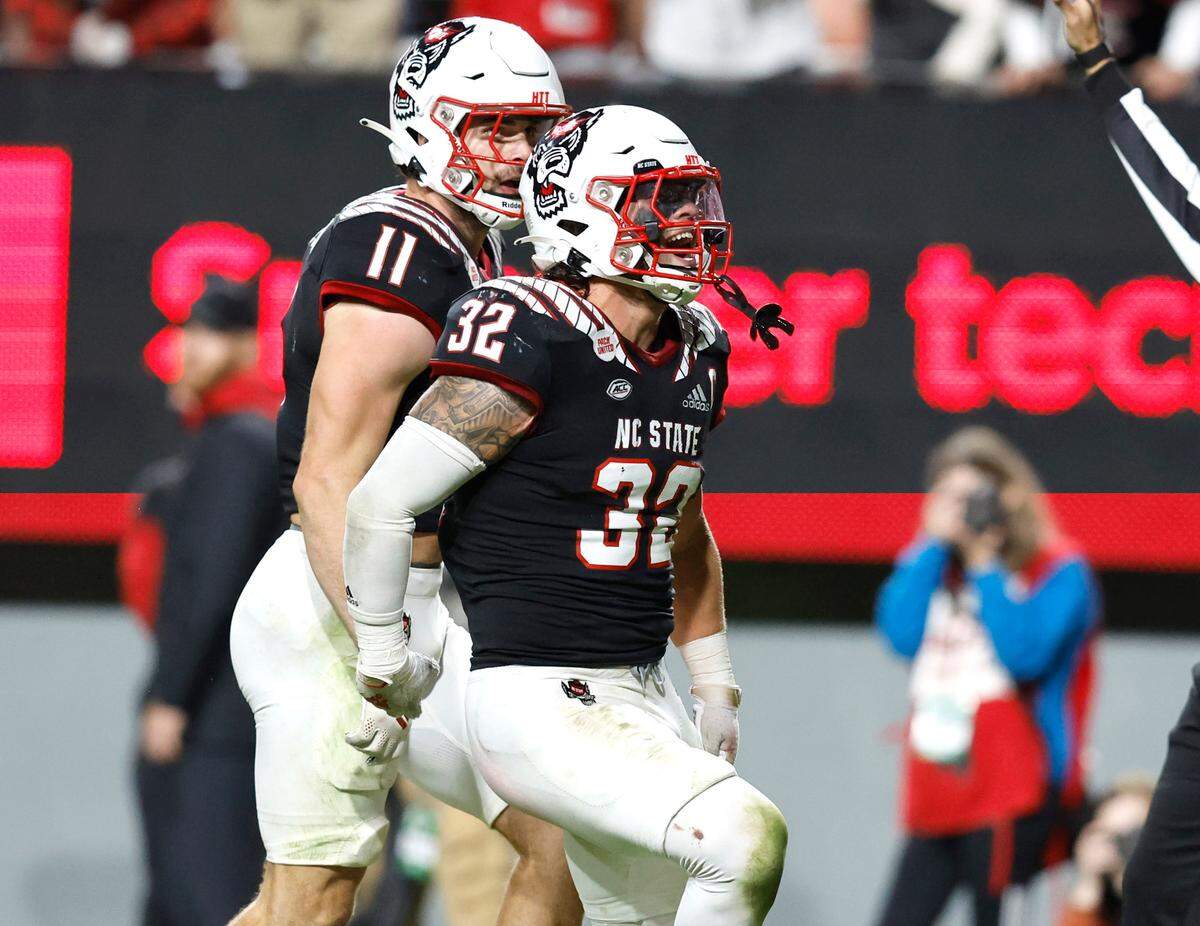 N.C. State linebacker Drake Thomas (32) celebrates after sacking Virginia Tech quarterback Grant Wells during the second half of N.C. State’s 22-21 victory over Virginia Tech at Carter-Finley Stadium in Raleigh, N.C., Thursday, Oct. 27, 2022. Payton Wilson (11) celebrates with Thomas.