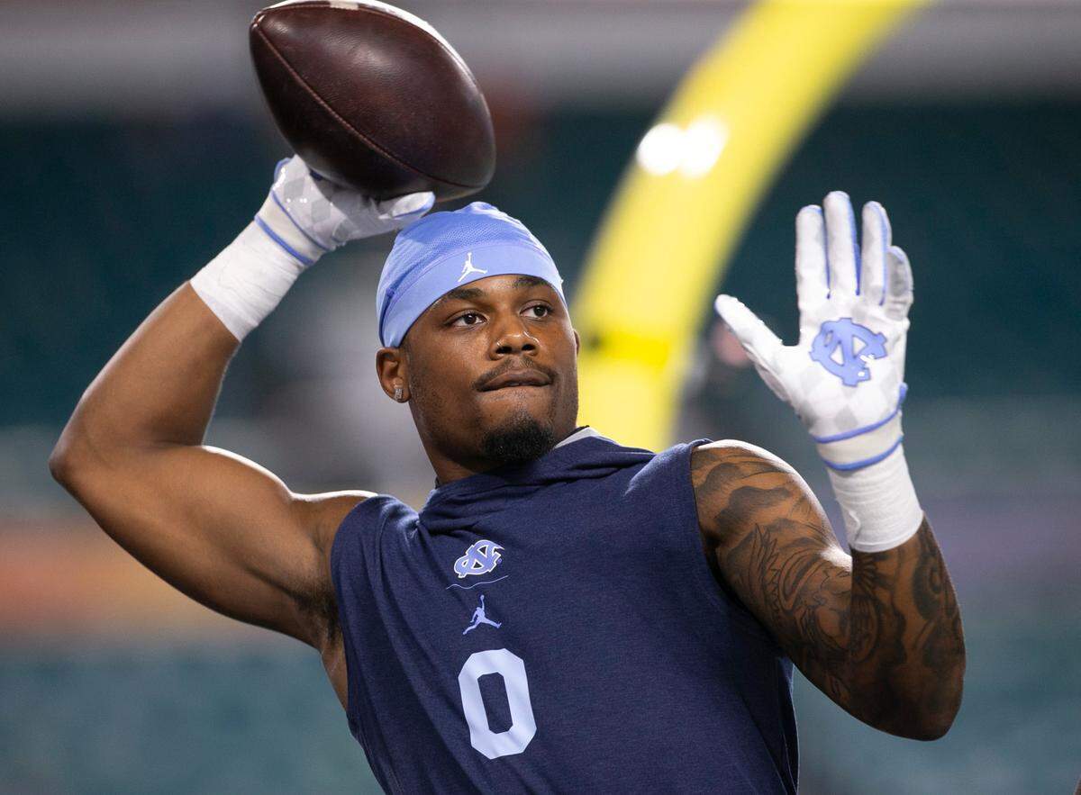 Former North Carolina defensive back Ja’Qurious Conley arms up with his teammates for a 2021 game at the Orange Bowl in Miami Gardens, Florida. 