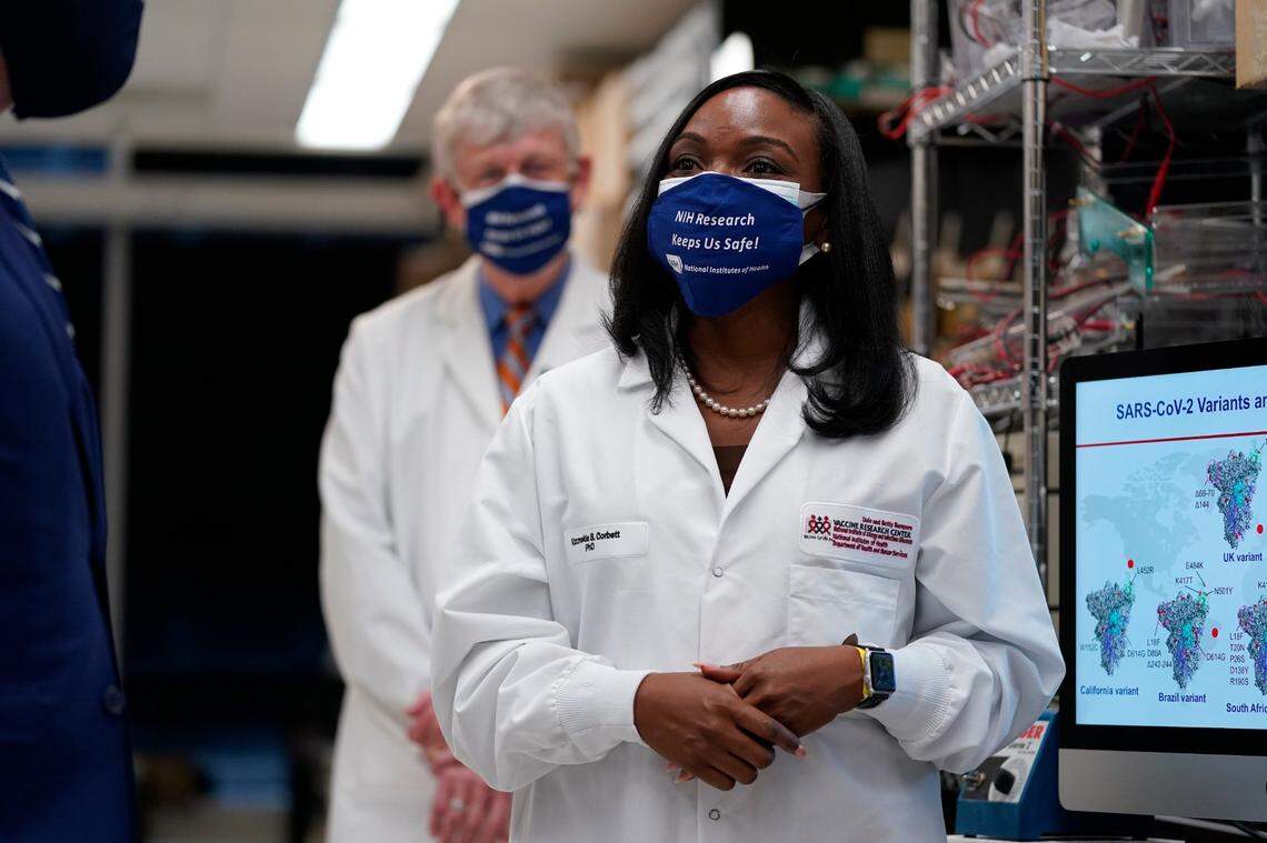 President Joe Biden, left, listens as Kizzmekia Corbett, an immunologist with the Vaccine Research Center at the National Institutes of Health (NIH), right, speaks during a visit at the Viral Pathogenesis Laboratory at the NIH, Thursday, Feb. 11, 2021, in Bethesda, Md. NIH Director Francis Collins is second from left.