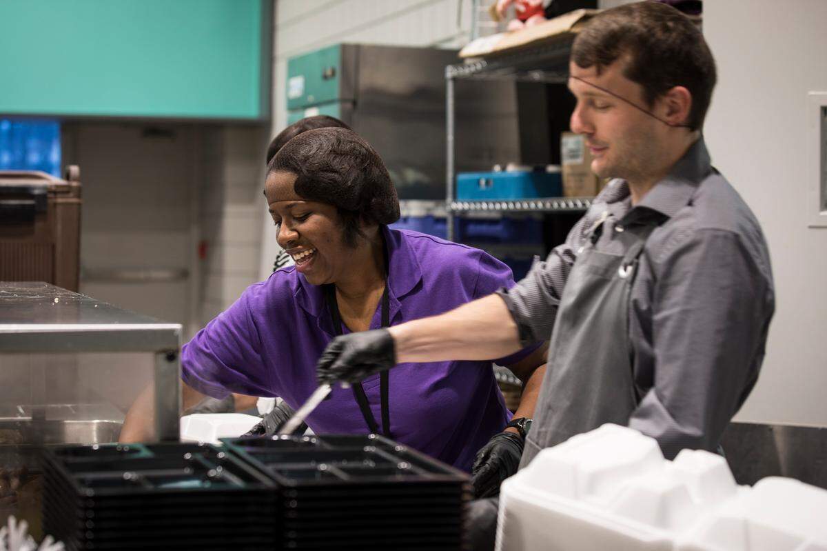 Shona Wynn, middle, and Adrian L’esperance, right, prepare breakfast for shelter residents at the Urban Ministries of Durham on Thursday morning, March 19, 2020. Volunteering is a great way to make new friends when you move to a new town.