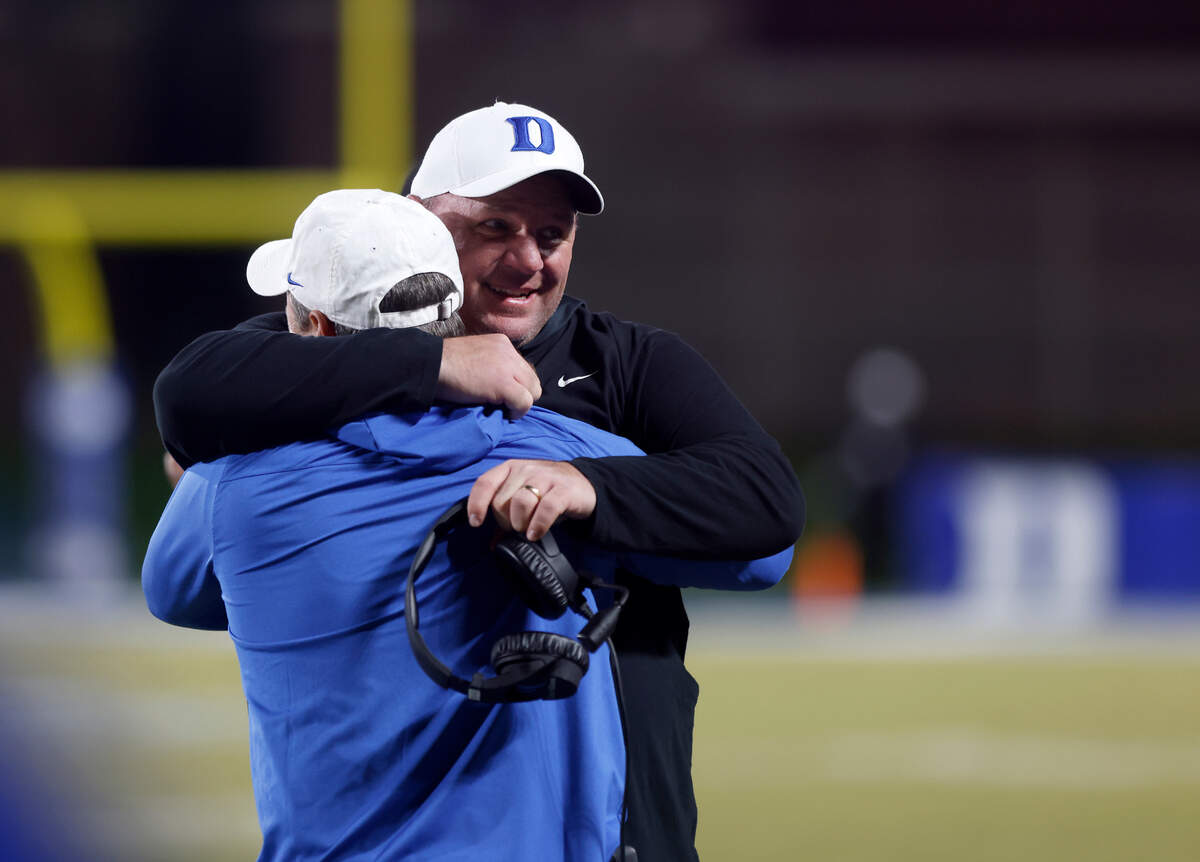 Duke head coach Mike Elko gets a hug on the sideline in the closing seconds of the Blue Devils’ 34-31 win over Wake Forest at Wallace Wade Stadium on Saturday, Nov. 26, 2022, in Durham, N.C.