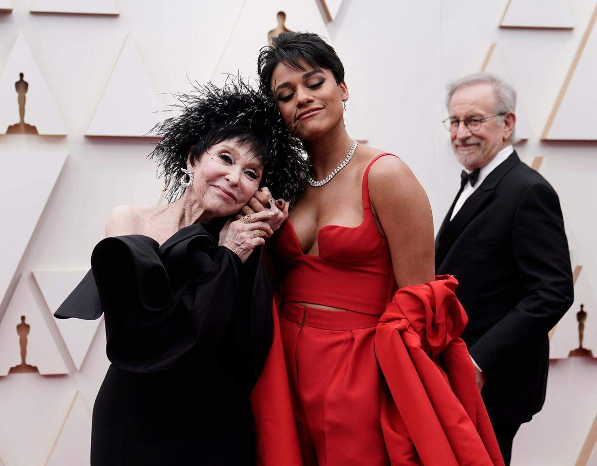 Rita Moreno, left, and Ariana DeBose arrive at the Oscars on Sunday, March 27, 2022, at the Dolby Theatre in Los Angeles. Looking in background is Steven Spielberg.
