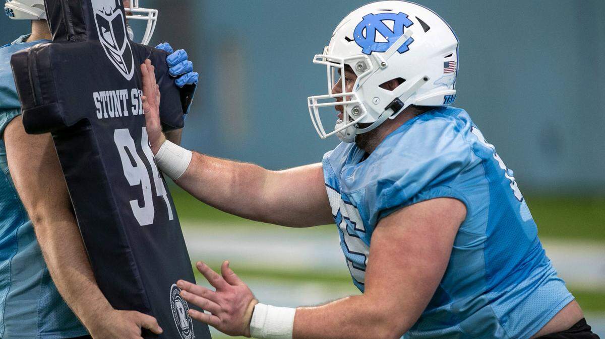North Carolina offensive lineman Corey Gaynor (65) runs through a blocking a drill during the opening day of the Tar Heels’ spring football practice on Tuesday, March 1, 2022 in Chapel Hill, N.C.