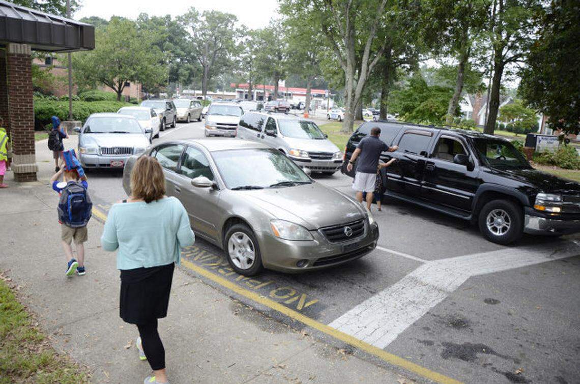 Wendell Elementary School teachers help students find their rides in the busy school carpool lane last Wednesday.