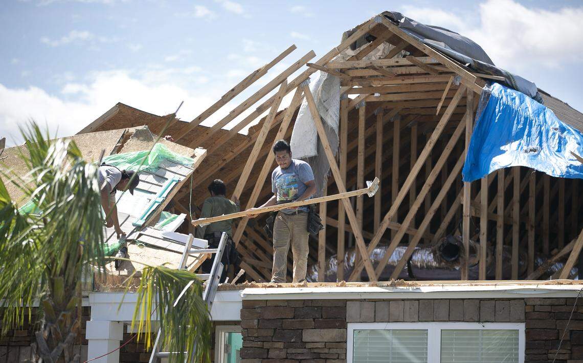 Construction crews work to repair and cover the roof of a home on Slippery Rock Way in The Farm at Brunswick subdivision on Friday, September 6, 2019 in Carolina Shores, N.C. A tornado spawned from Hurricane Dorian struck the neighborhood on Thursday morning, September 5, 2019 damaging 40 homes, ten of them seriously.