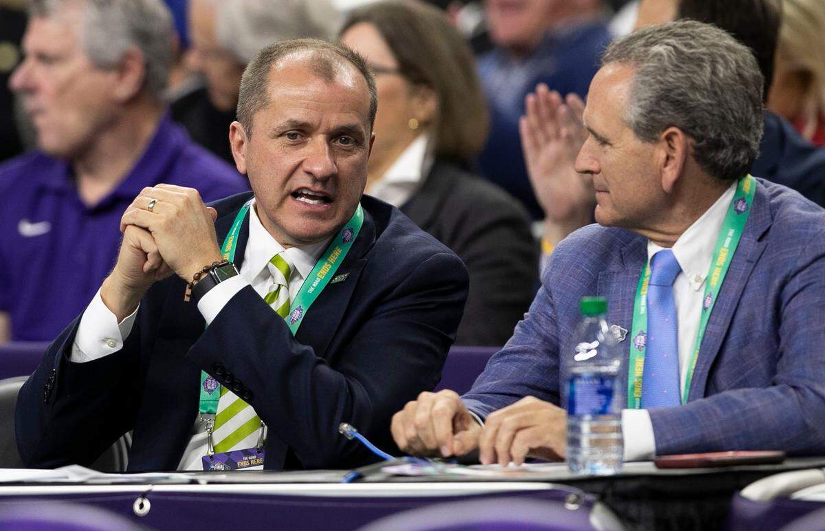 ACC Commissioner Jim Phillips talks with North Carolina Athletic Director Bubba Cunningham during a NCAA Tournament game.