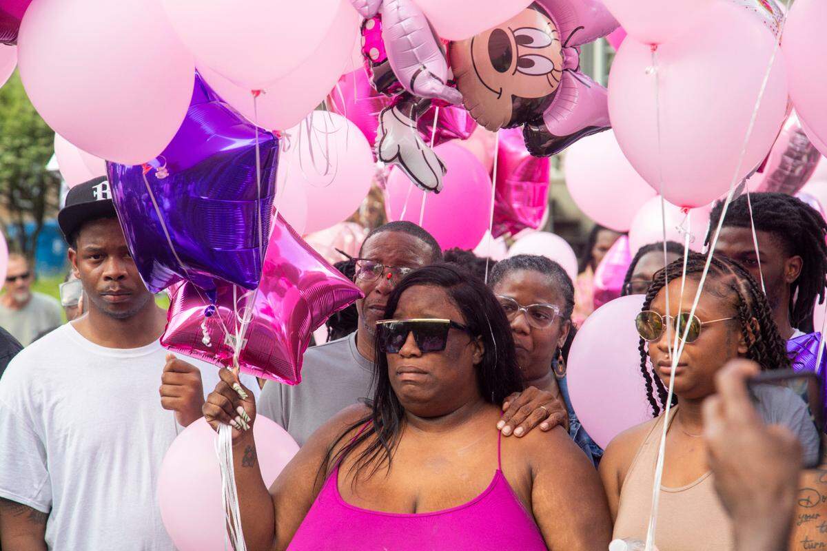 Brittany Dash, the mother of 5-year-old Khloe Fennell, center, prepares to release balloons with family, friends and neighbors during a vigil Friday, July 7, 2023 in Durham. Fennell was shot and killed on Wednesday. Her 15-year-old cousin was babysitting her. She was shot multiple times and survived.