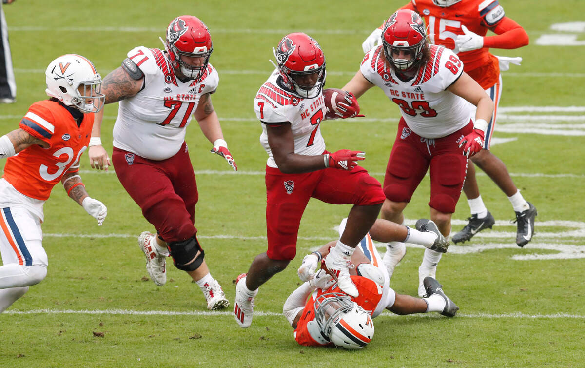 N.C. State running back Zonovan Knight (7) steps over Virginia linebacker Charles Snowden (11) as he runs for yards during the second half of N.C. State’s 38-21 victory over Virginia at Scott Stadium in Charlottesville, Va., Saturday, Oct. 10, 2020.