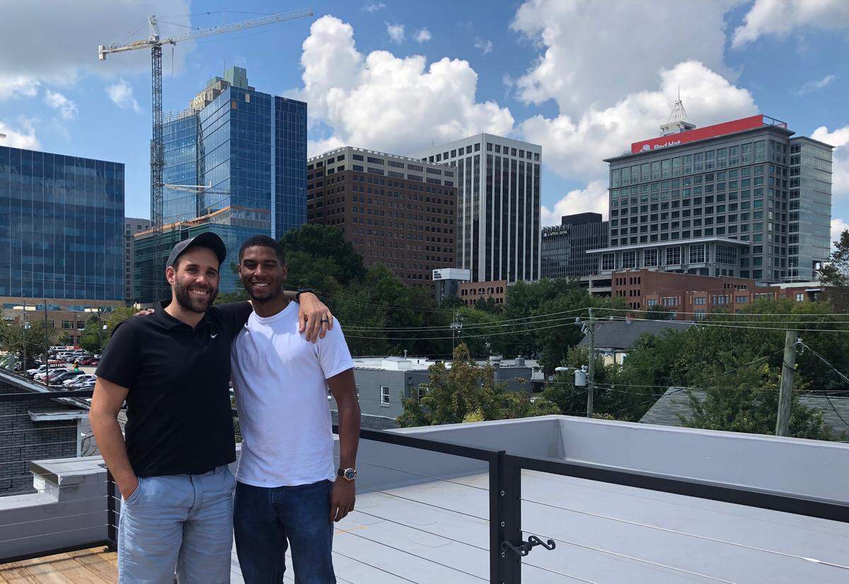 Loading Dock employees, Clark Rinehart, right, and Jalen Hatton, stand on the deck of Loading Dock’s newest community in Raleigh, located in the Prince Hall district.