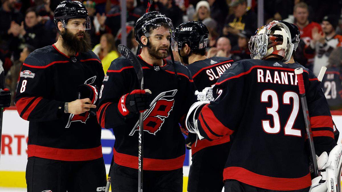 Carolina Hurricanes goaltender Antti Raanta (32) is congratulated by Jordan Martinook, center, and Brent Burns (8) after the team’s win over the Philadelphia Flyers in an NHL hockey game in Raleigh, N.C., Friday, Dec. 23, 2022. (AP Photo/Karl B DeBlaker)