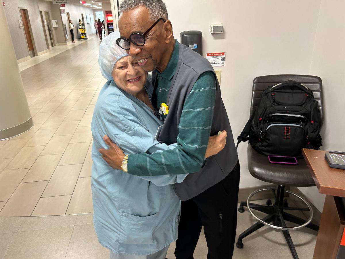 Walter Moreland hugs Dorothy Kaleel in the hallway where he sings at WakeMed every Friday.