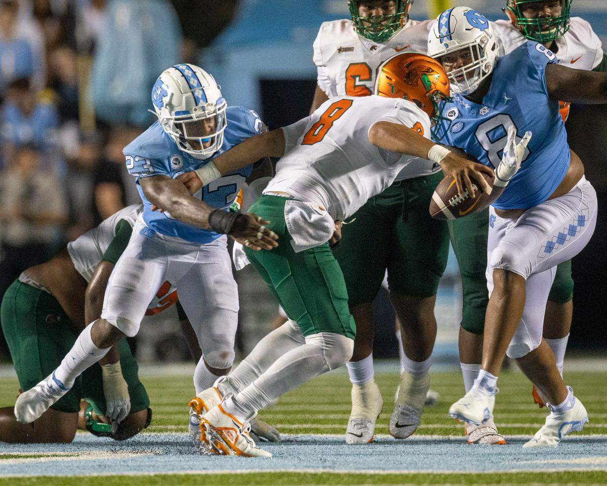North Carolina’s Power Echols (23) and Myles Murphy (8) sack Florida A&M quarterback Jeremy Moussa (8) in the second quarter on Saturday, August 27, 2022 at Kenan Stadium in Chapel Hill, N.C.