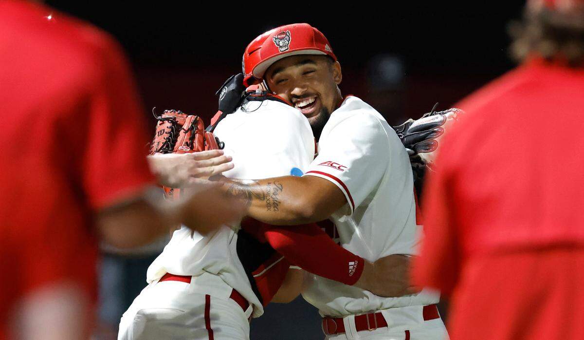 N.C. State’s Jacob Cozart (14) hugs Derrick Smith (25) after the final out in N.C. State’s 6-4 victory over South Carolina in the NCAA Raleigh Regional at Doak Field Saturday, June 1, 2024.