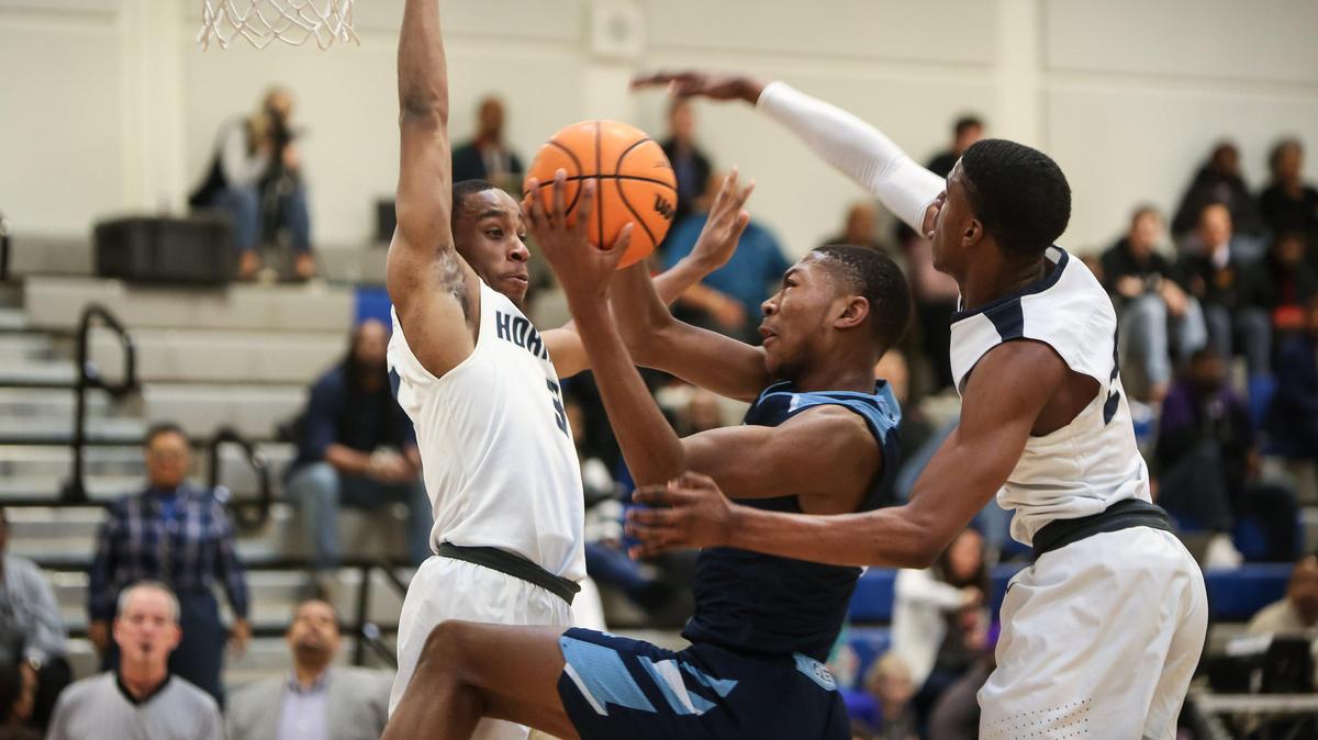 Millbrook’s Jalen McCoy (2) scores on a drive while being fouled as Hillside defenders Mustapha Shah (3) and Elijah Thomas (24) converge during the men’s basketball game between Hillside and Millbrook at the Garner Showcase on Monday, January 20, 2020. Millbrook won the game 86-70.