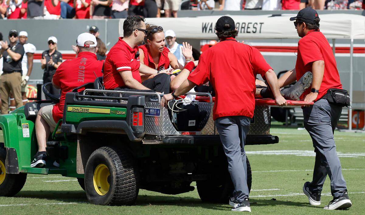 N.C. State quarterback Grayson McCall raises his hand while being taken off the field after being injured during the first half of N.C. State’s game against Wake Forest at Carter-Finley Stadium in Raleigh, N.C., Saturday, Oct. 5, 2024.