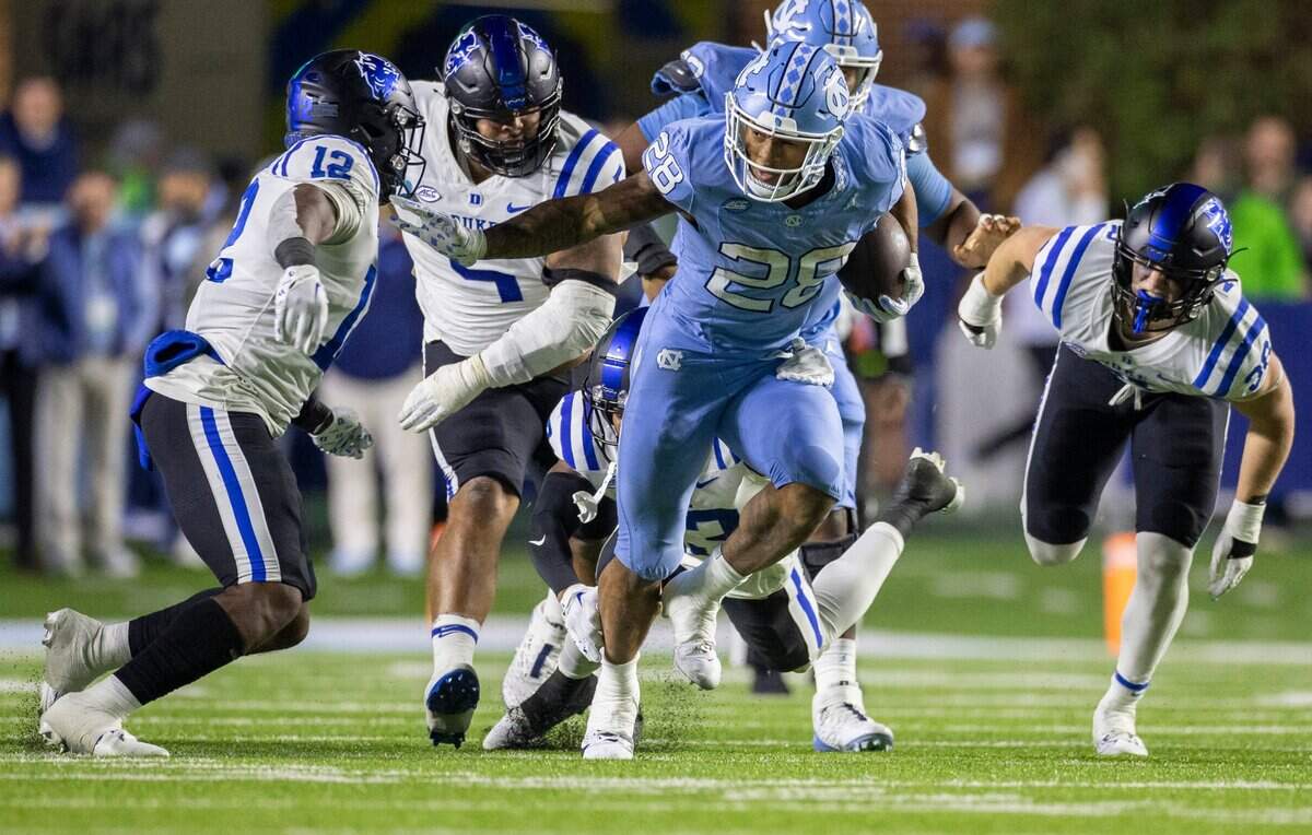 North Carolina running back Omarion Hampton (28) looks for running room as he picks up 14 yards against Duke’s Tre Freeman (12) in the second quarter on Saturday, Nov. 11, 2023 at Kenan Stadium in Chapel Hill, N.C.