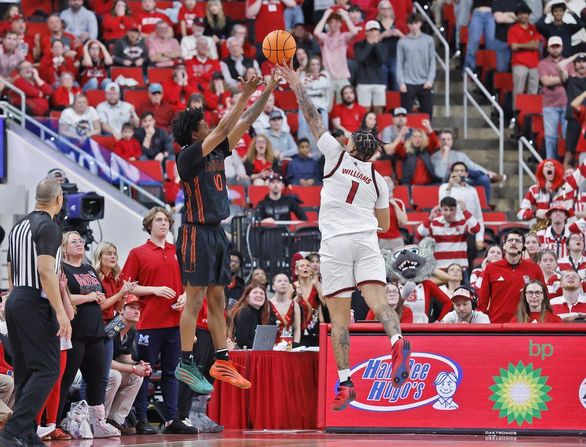 N.C. State’s Darrion Williams fouls Miami’s Tru Washington in the final minute of the Wolfpack’s 77-76 loss on Saturday, Feb. 14, 2026, at Lenovo Center in Raleigh, N.C. 