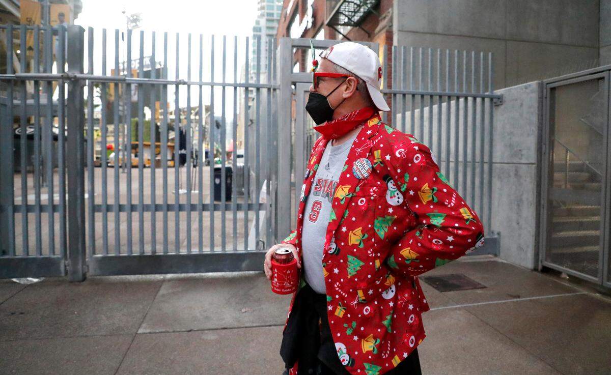 N.C. State graduate Alan Hauser of Newport Beach, CA, stands outside the gates to Petco Park in San Diego, CA Tuesday, Dec. 28, 2021. Hauser was hoping to get a glimpse of the field after UCLA pulled out of the Holiday Bowl, canceling the game. Hauser said he found out the game was cancelled from his brother in North Carolina. “I couldn’t believe it” said Hauser. “I am so bummed.”