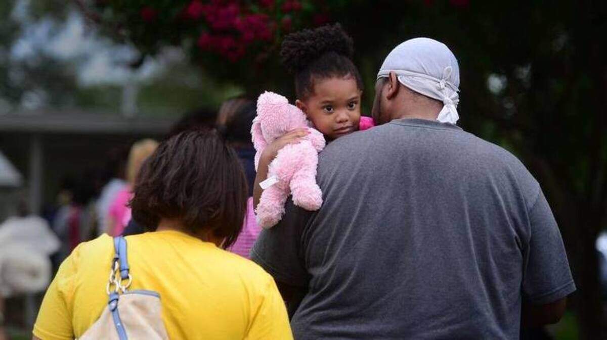 A Mecklenburg County family waits in line to get into Crisis Assistance Ministry in Charlotte in this 2014 file photo.