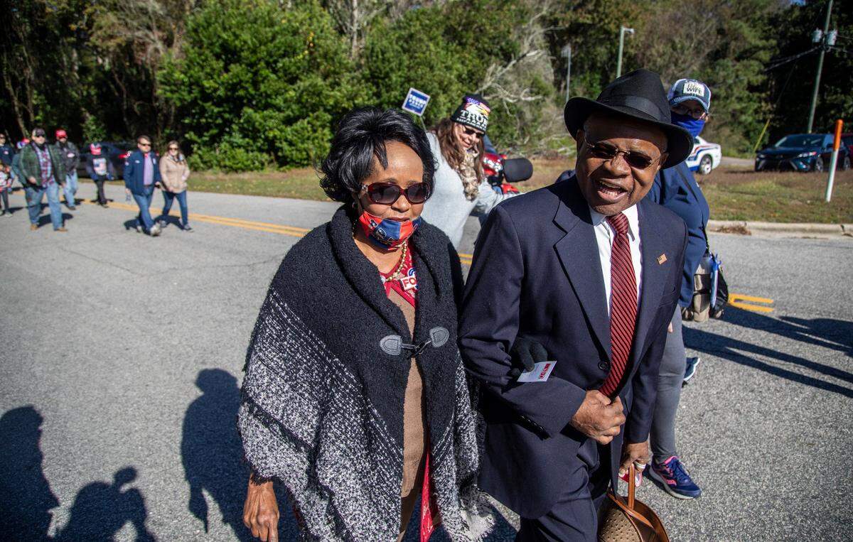 President Donald Trump supporters, Larry and Gloria King of Rutherfordton, make their way to a campaign rally, Monday, Nov. 2, 2020 at Fayetteville Regional Airport.