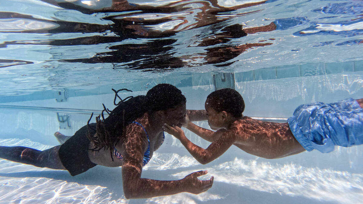 Cousins Mackenzie Riley, 12, and Zayzay Hamilton, 5, play underwater at A.D. Clark Pool on Wednesday, July 26, 2023, in Chapel Hill, N.C.